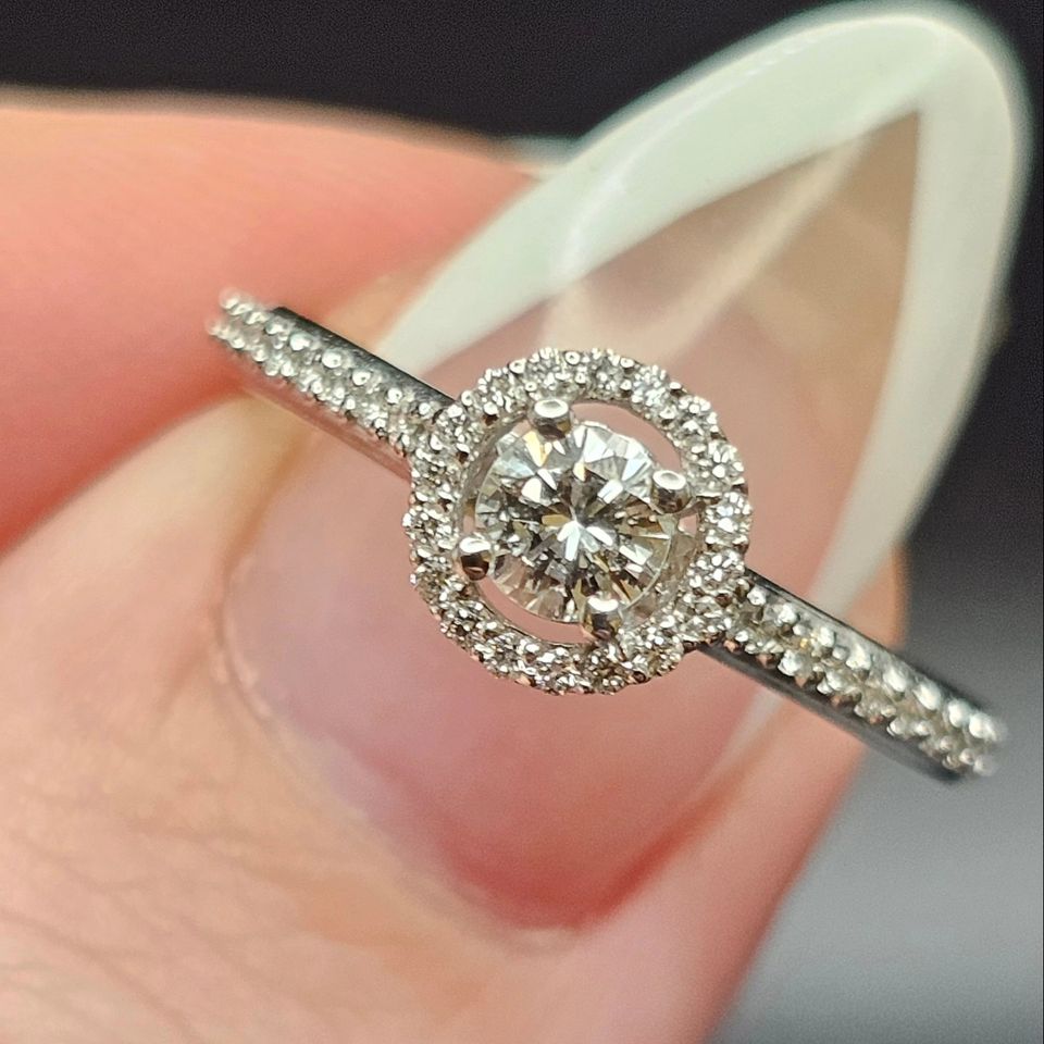 14k white gold engagement ring set, with 1 diamond (0.51  ct)  and 10 round cut diamonds totaling 0.21 ct.