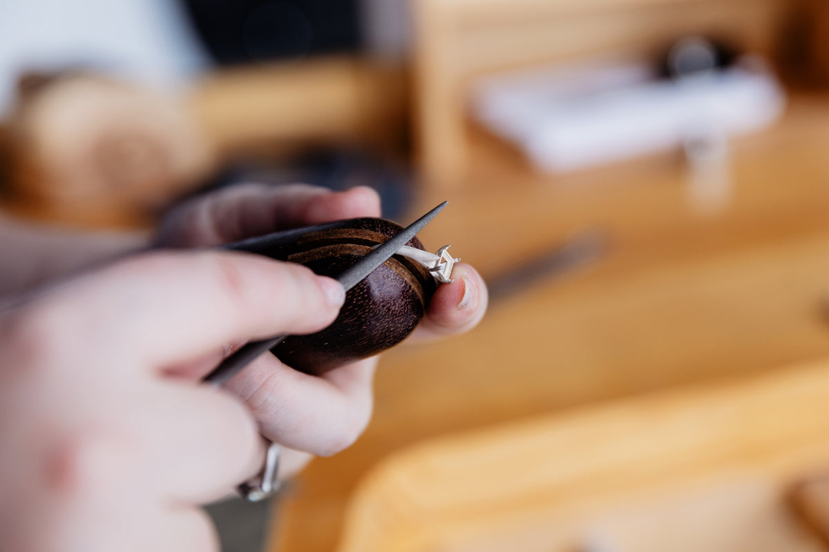 A ring being hand filed at the bench