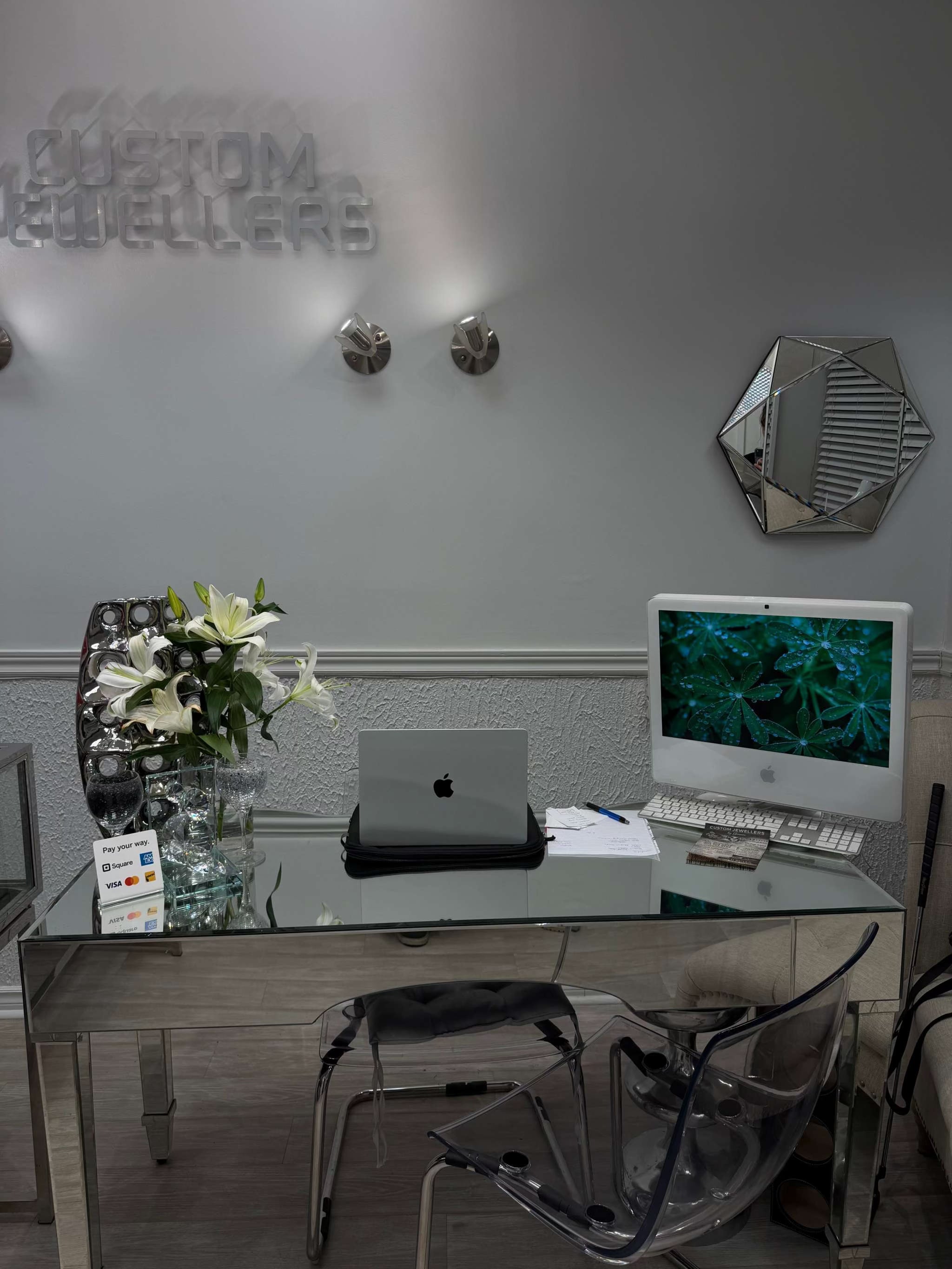 Modern office desk with computer setup and decor elements.