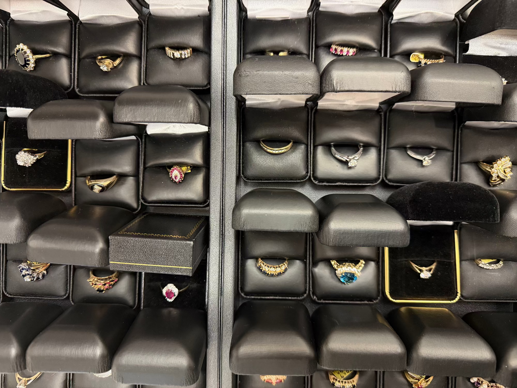 Jewelry display with various rings in black boxes.