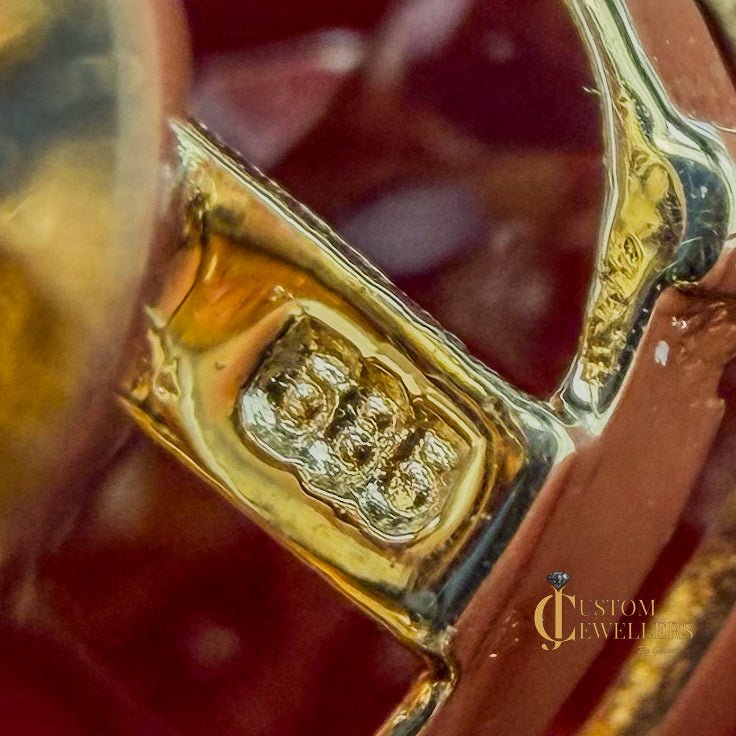 Close-up of red ruby studs showing a 14k "585" gold purity stamp.