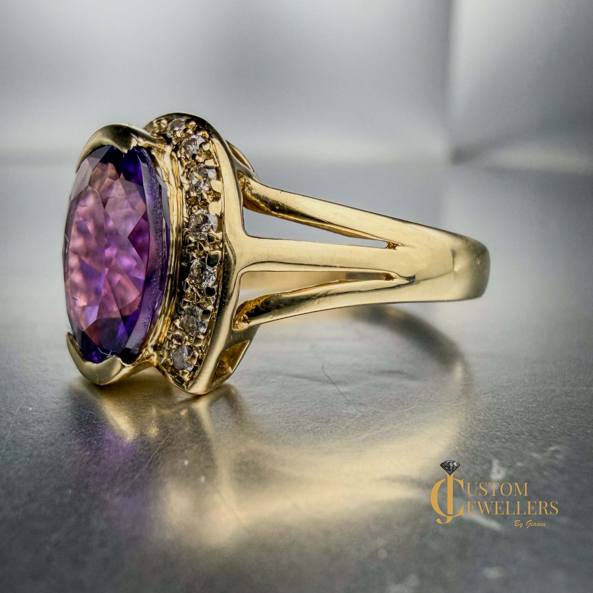 A yellow gold ring featuring a large oval-cut purple amethyst centre stone, accented by small diamonds set along a half-halo edge.