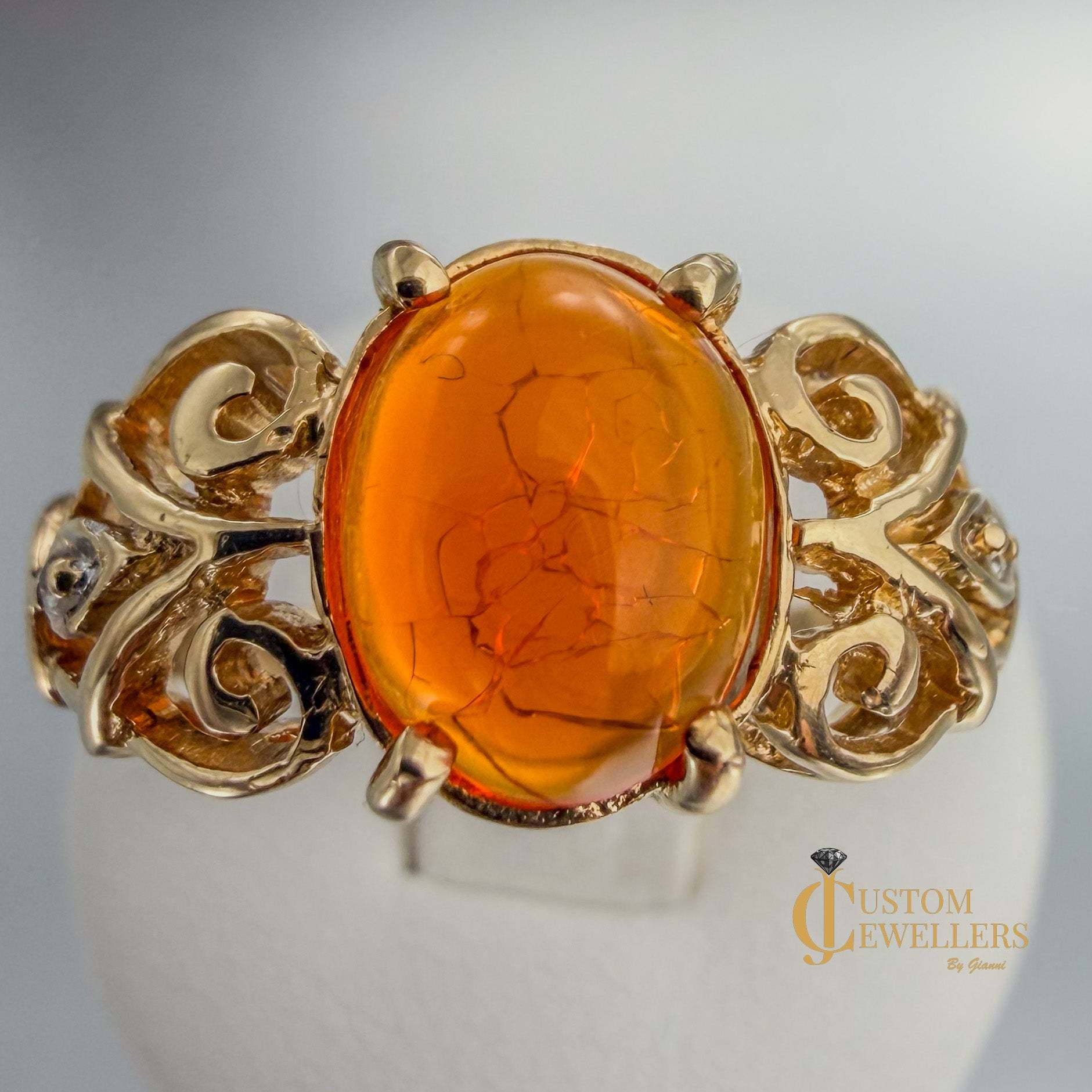 Rare and unique 14k yellow gold ring with oval-cut orange copal stone and two small diamonds