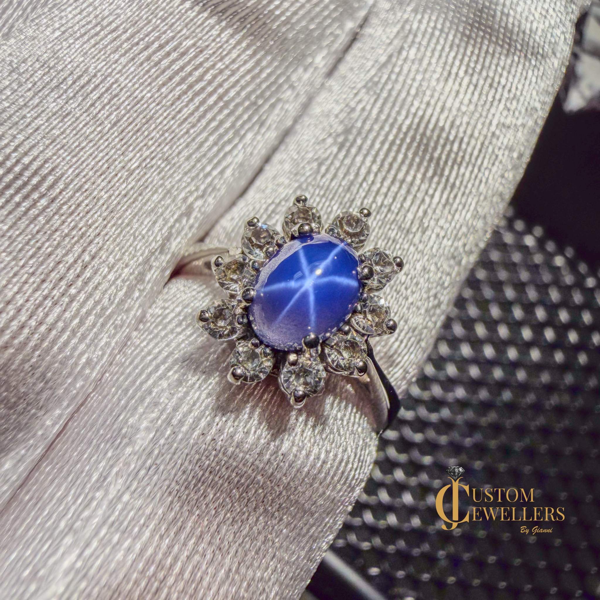 Star sapphire ring in 10k white gold with diamond halo