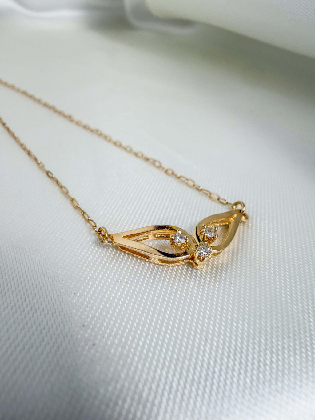 14k yellow gold whale tail necklace with triple diamond pendant on paperclip chain
