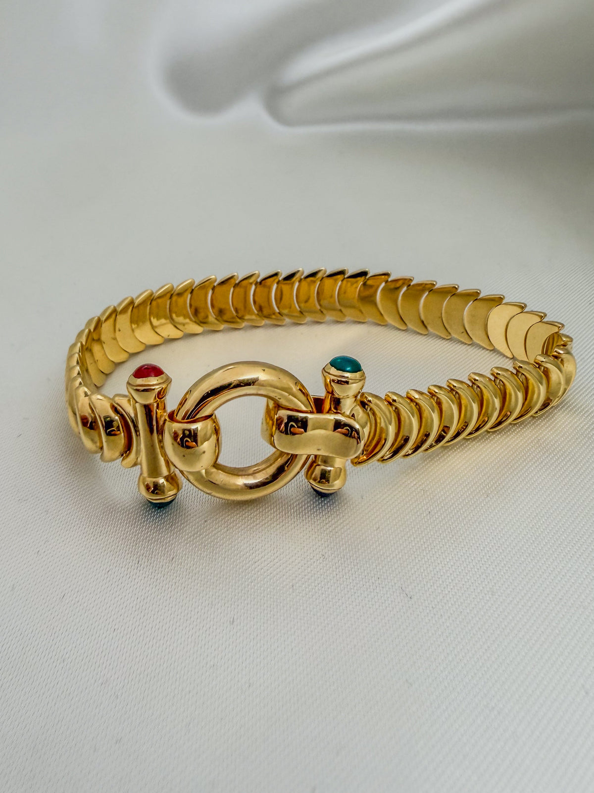Custom 14kt Bracelet flexible yellow gold half-moon chevron link design with oversized door-knocker clasp and two colorful gemstones.