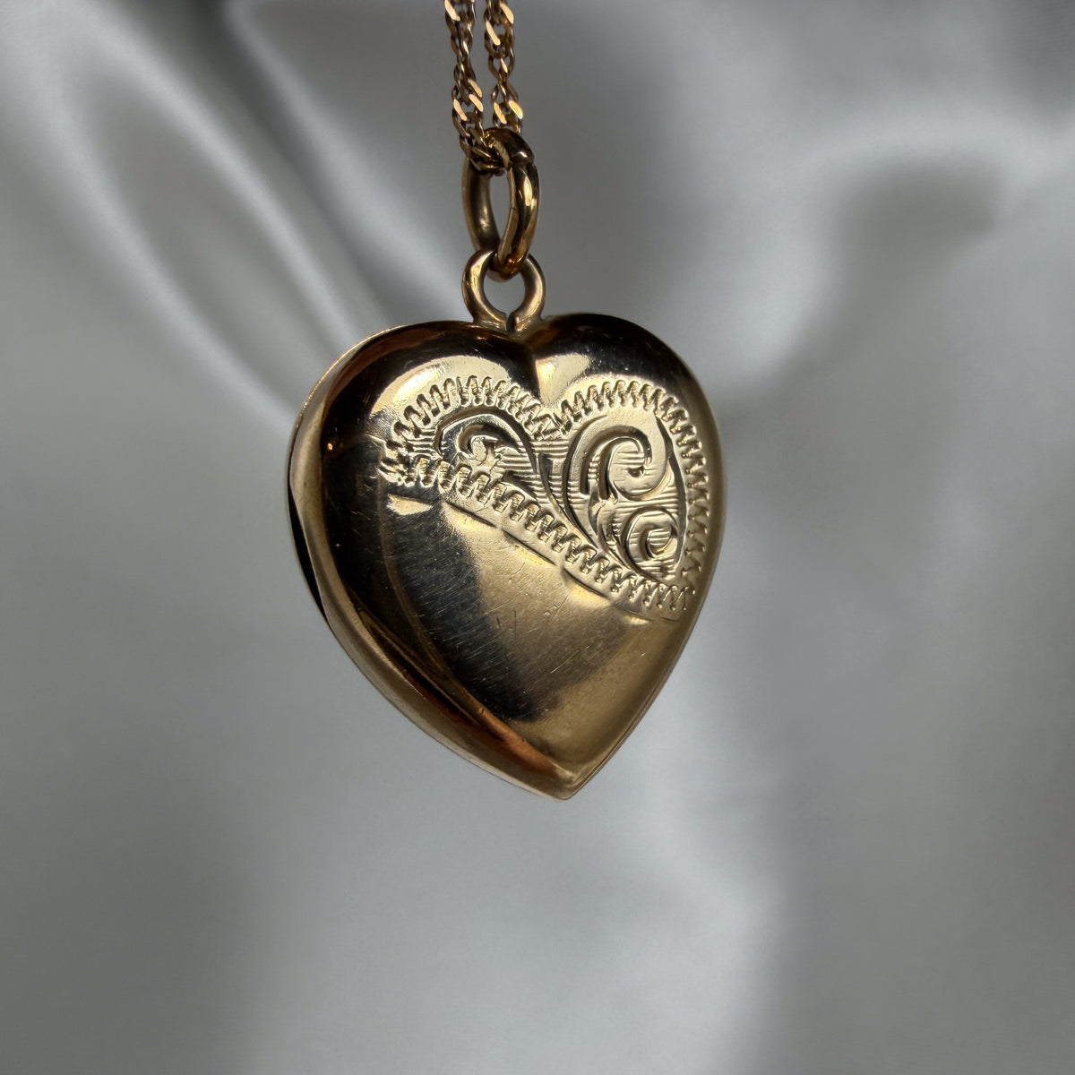 Vintage Heart Locket in polished gold-tone metal with an engraved scrollwork heart design and matching chain.