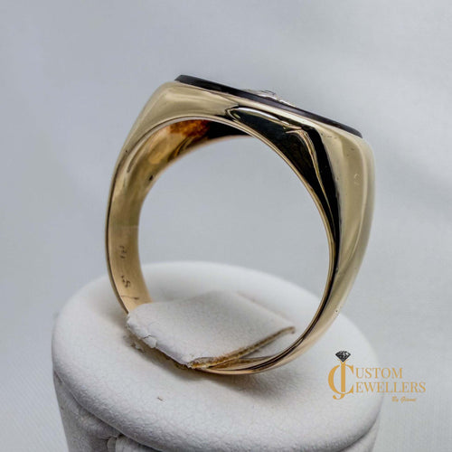Gold ring on a white cushion with 'Custom Jewellers' branding.