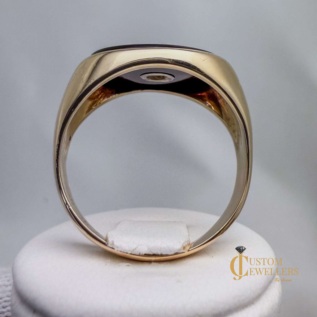 Gold ring on a white stand with 'Custom Jewellers' branding.