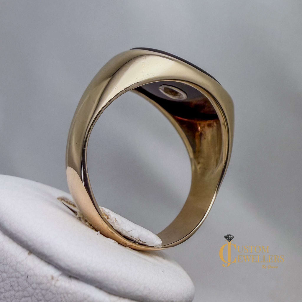 Gold ring on a white cushion with a gray background
