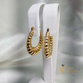 Seashell-inspired 14kt yellow gold hollow oval hoop earrings with graduated ripples