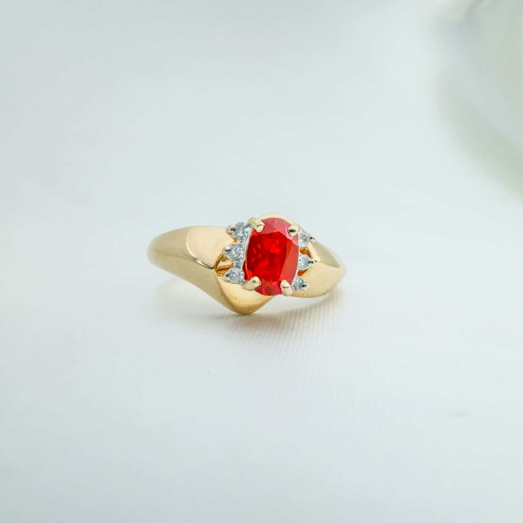 14k yellow gold ring with a vivid red-orange Fire Opal and Natural Diamonds, set in a sculpted angled band.