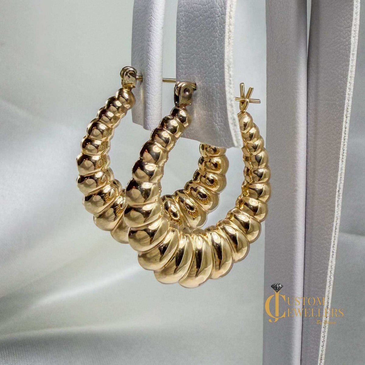 Gold hoop earrings inspired by seashell design with high polish finish